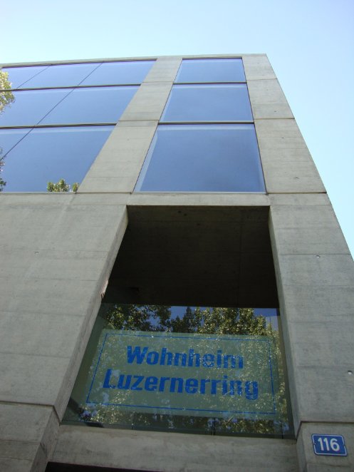 Sicht auf die Aussenfassade vom Wohnheim Luzernerring, ein grosses modernes Gebäude aus Beton und Glas.